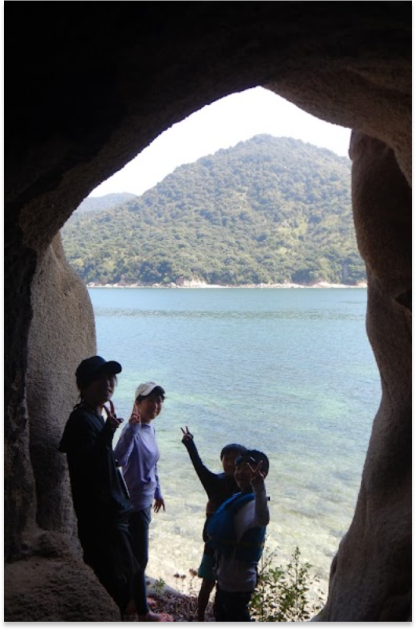 洞窟前でピースをしている人々